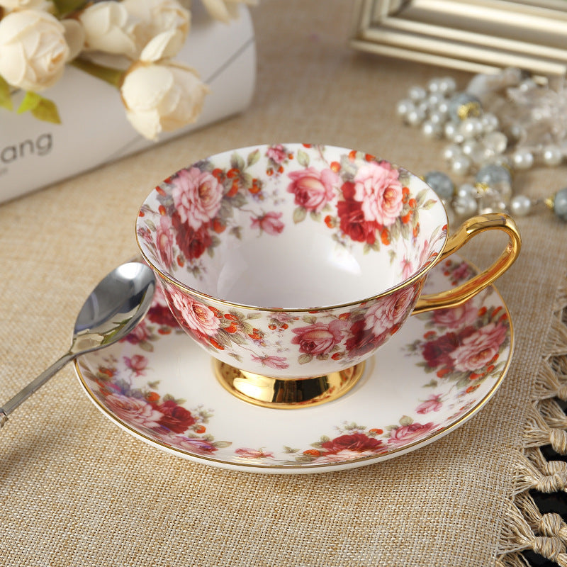 Elegant floral tea cup and saucer set with golden accents and a spoon, perfect for tea time.