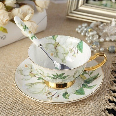 Élégant service à thé comprenant une tasse avec cuillère et soucoupe, ornés de motifs floraux et dorures.