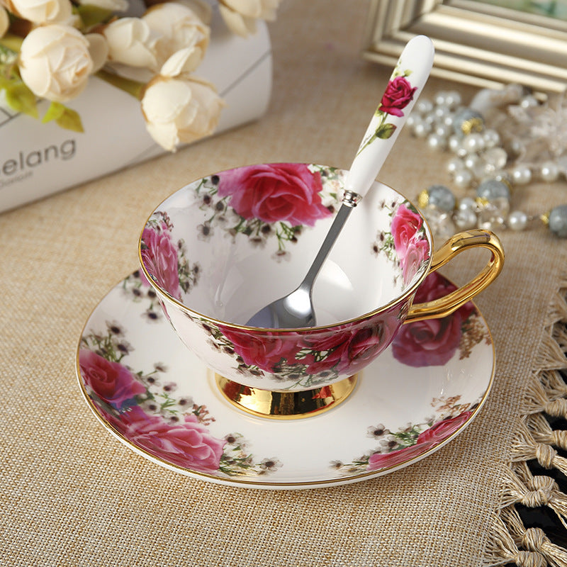 Elegant floral tea set with cup, saucer, and spoon featuring rose patterns and gold accents.