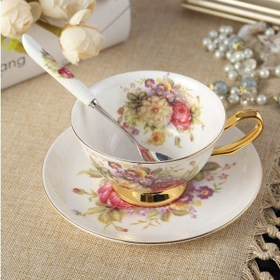 Service à thé élégant avec tasse florale, soucoupe et cuillère en porcelaine dorée.