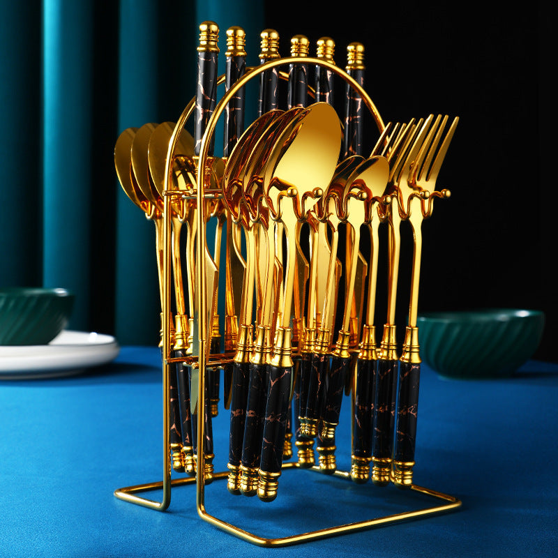 Ensemble de couverts occidentaux en acier inox doré, rangement élégant sur une table bleue.