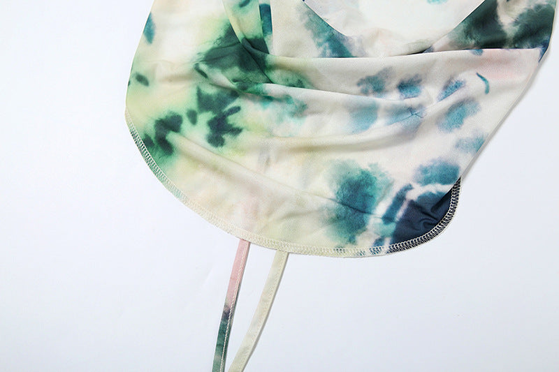 Close-up of the Naïa two-piece outfit top featuring a vibrant tie-dye pattern in green and blue.