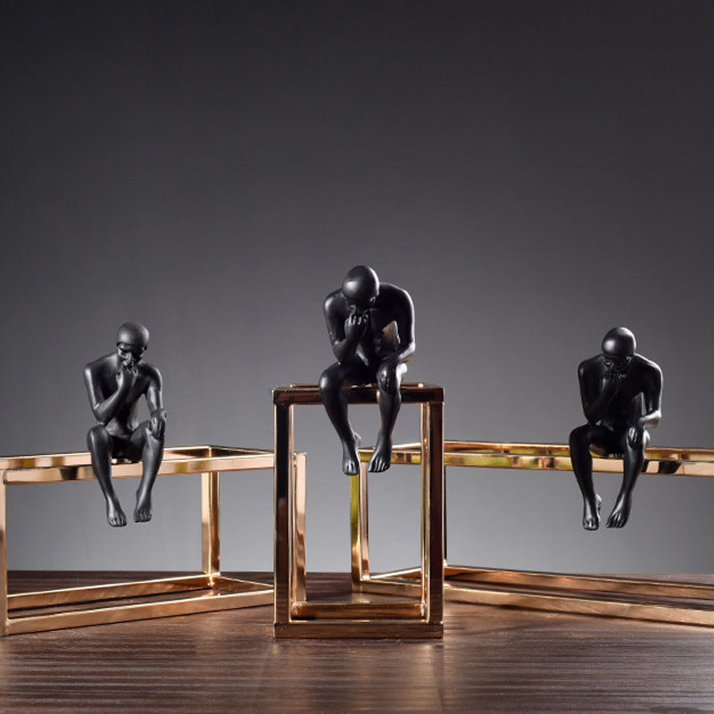 Statue design en métal noir sur structure dorée, décoration bureau moderne