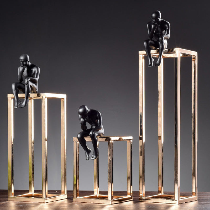 Statue design en métal noir sur structure dorée, décoration bureau moderne