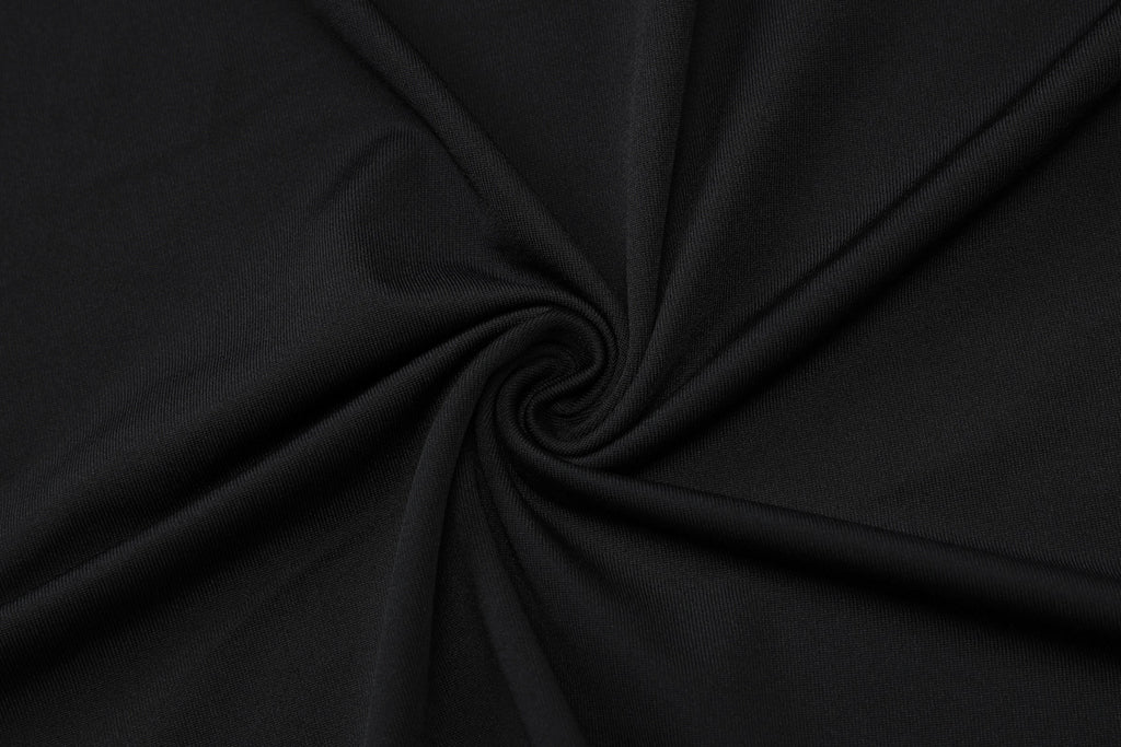 Black fabric twisted in a spiral pattern, showcasing its smooth texture and rich color.