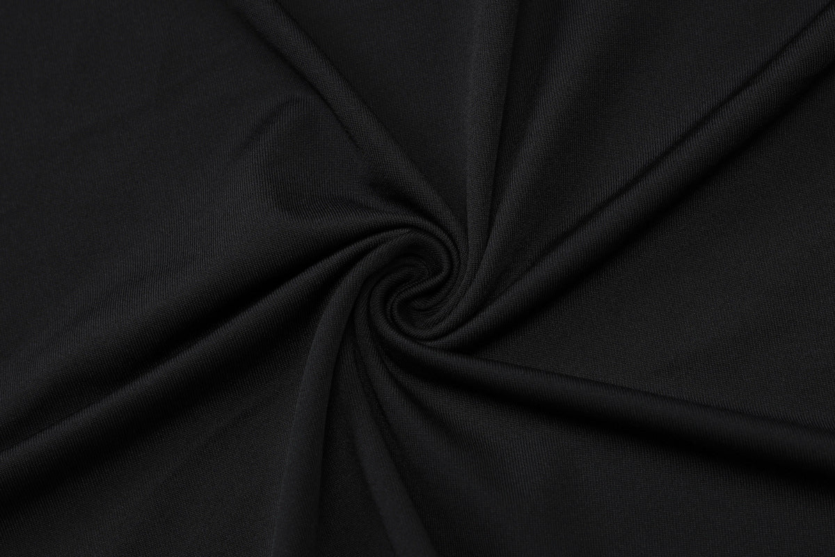 Black fabric twisted in a spiral pattern, showcasing its smooth texture and rich color.