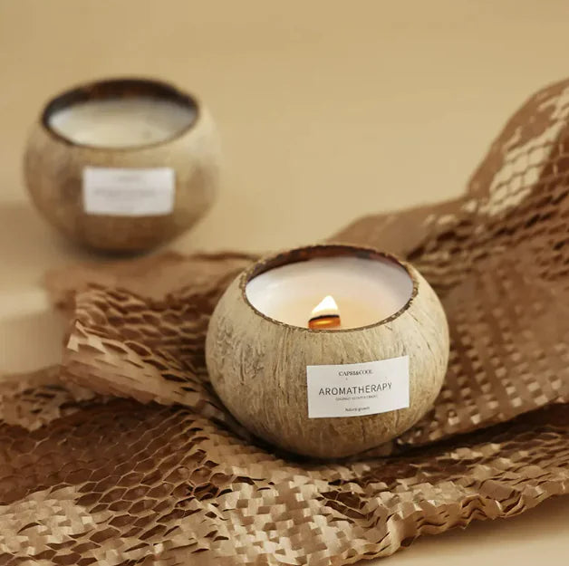 Coconut-scented aromatherapy candle in a natural-looking holder, set on textured brown fabric.